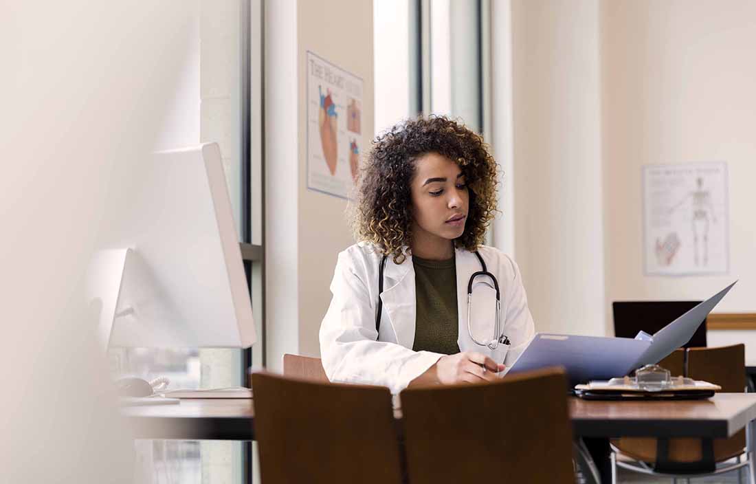 Healthcare worker sitting at a table, reading files