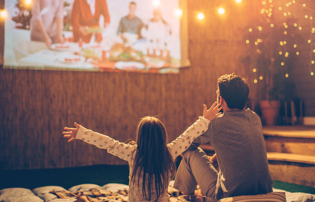 Image of child and adult watching family movie