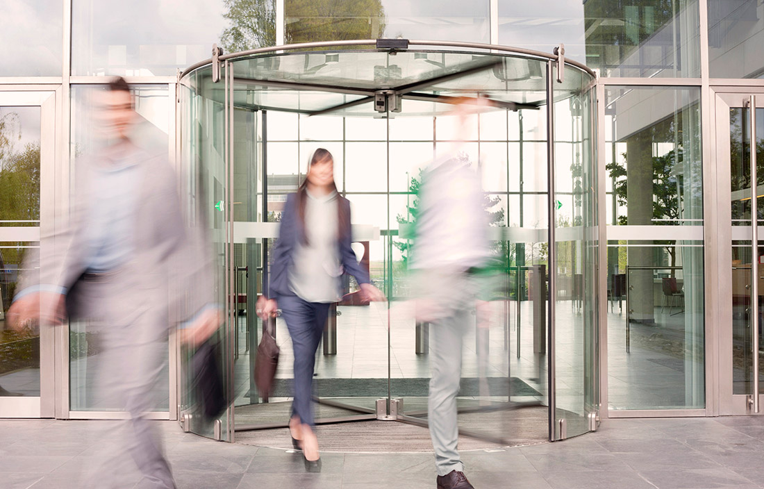 Image of people walking out of revolving doors