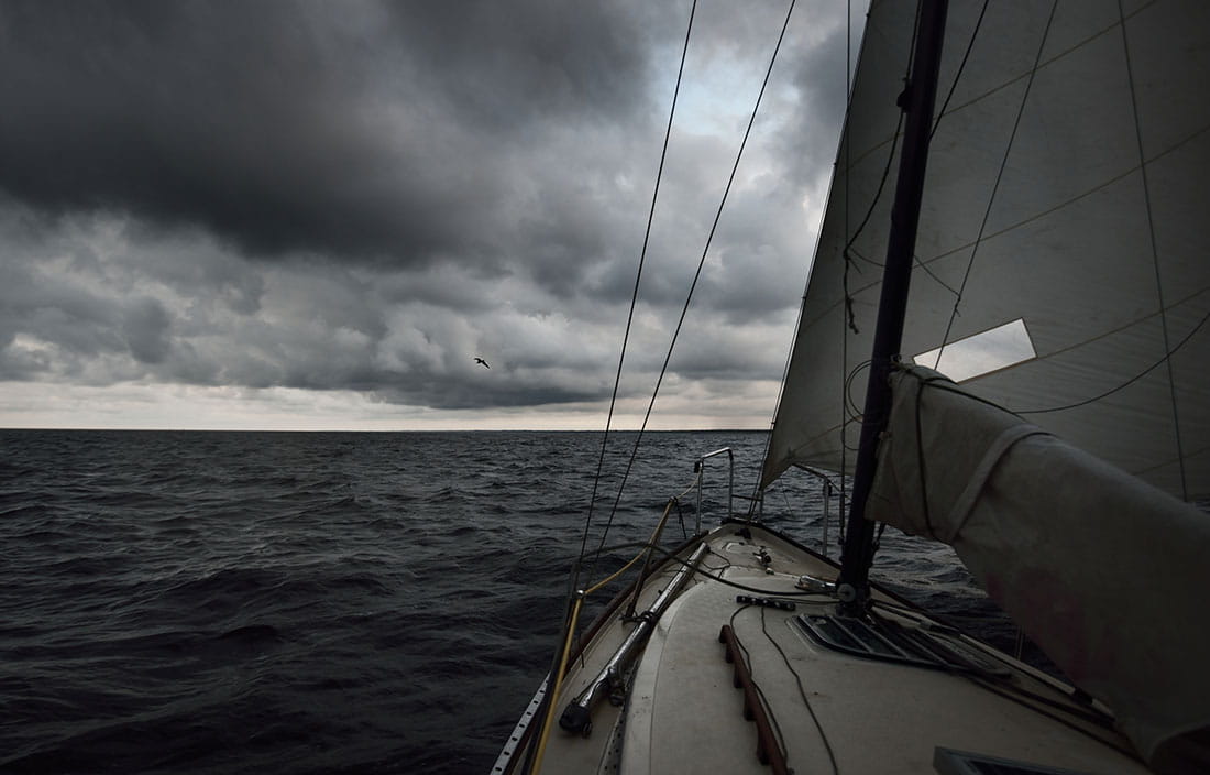 View of a stormy sea and cloudy sky from a sailboat.